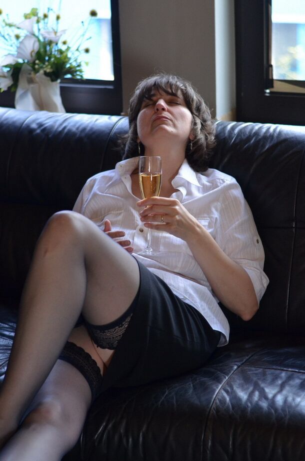 20P Femme mature expose ses seins et sa chatte en buvant du vin sur un canapé en cuir