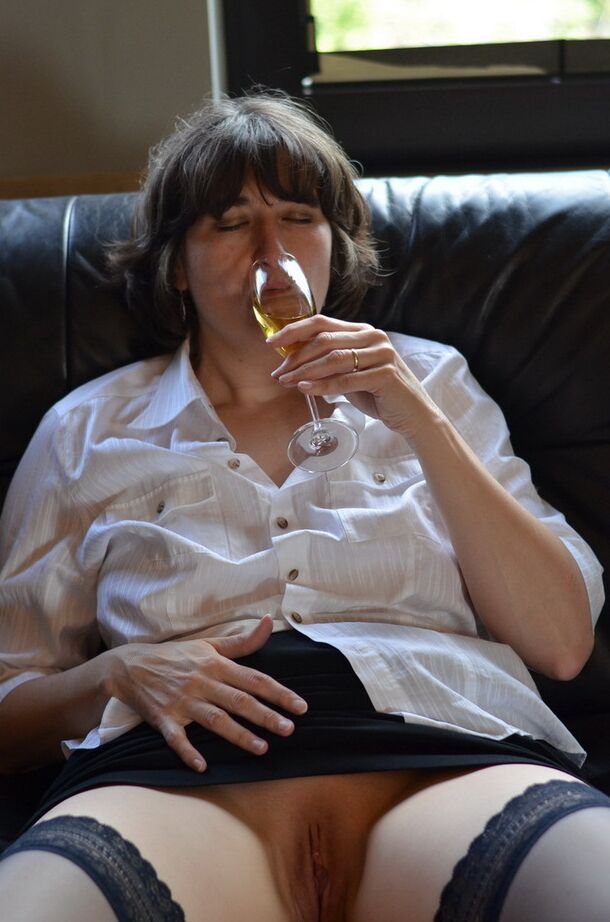 20P Femme mature expose ses seins et sa chatte en buvant du vin sur un canapé en cuir
