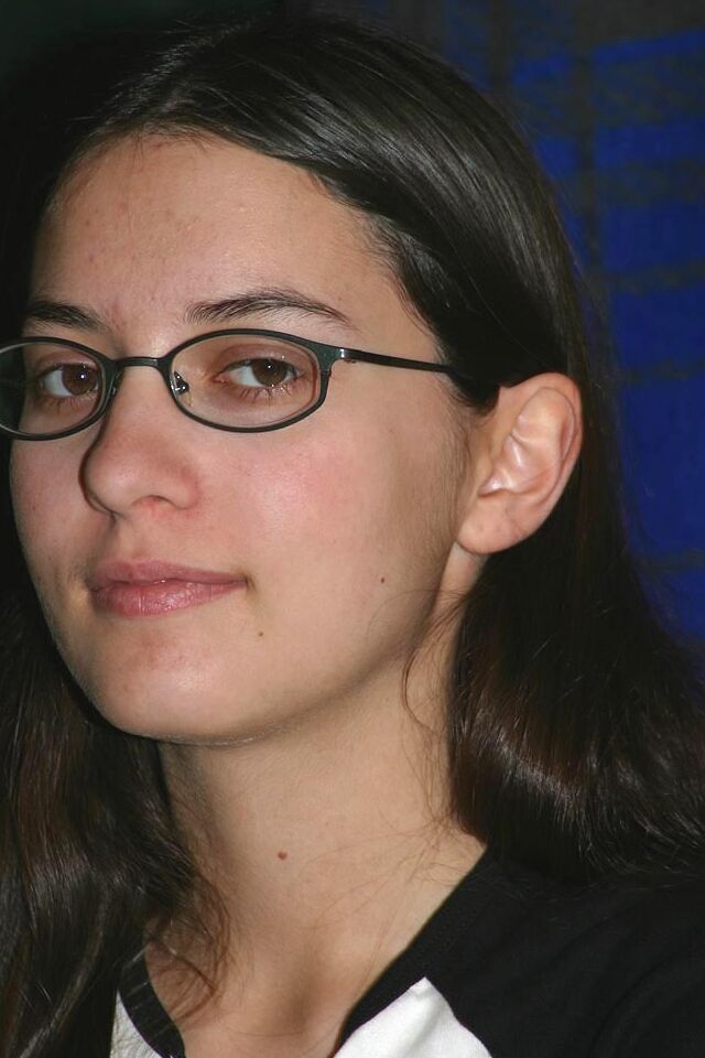 16P Garota amadora mantém os óculos enquanto se despe até ficar só de meias na cama