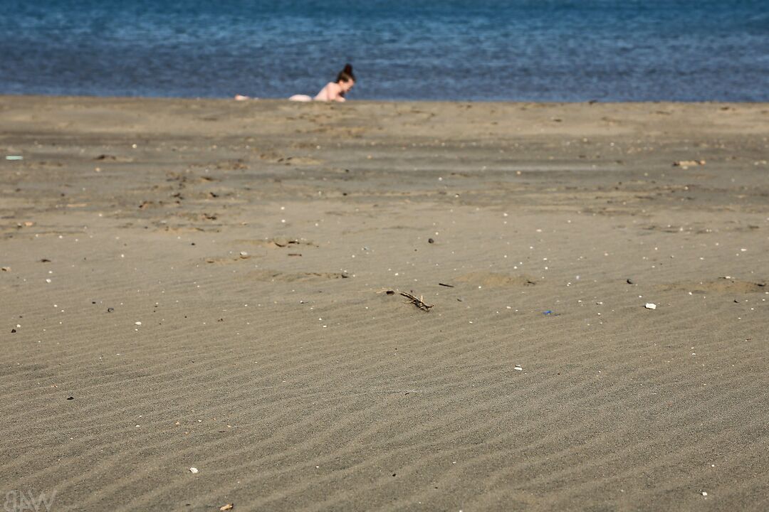 16P Beach beauty Emily sunbathing naked on the sand spreading long legs wide open