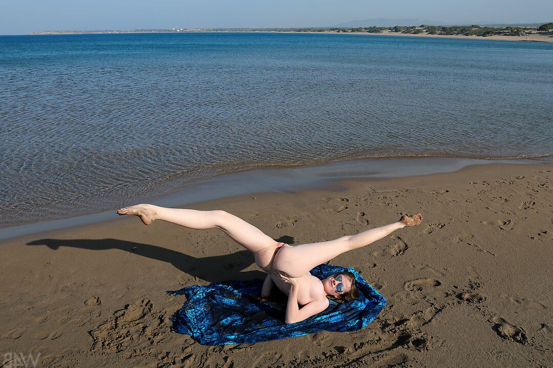 16P Beach beauty Emily sunbathing naked on the sand spreading long legs wide open
