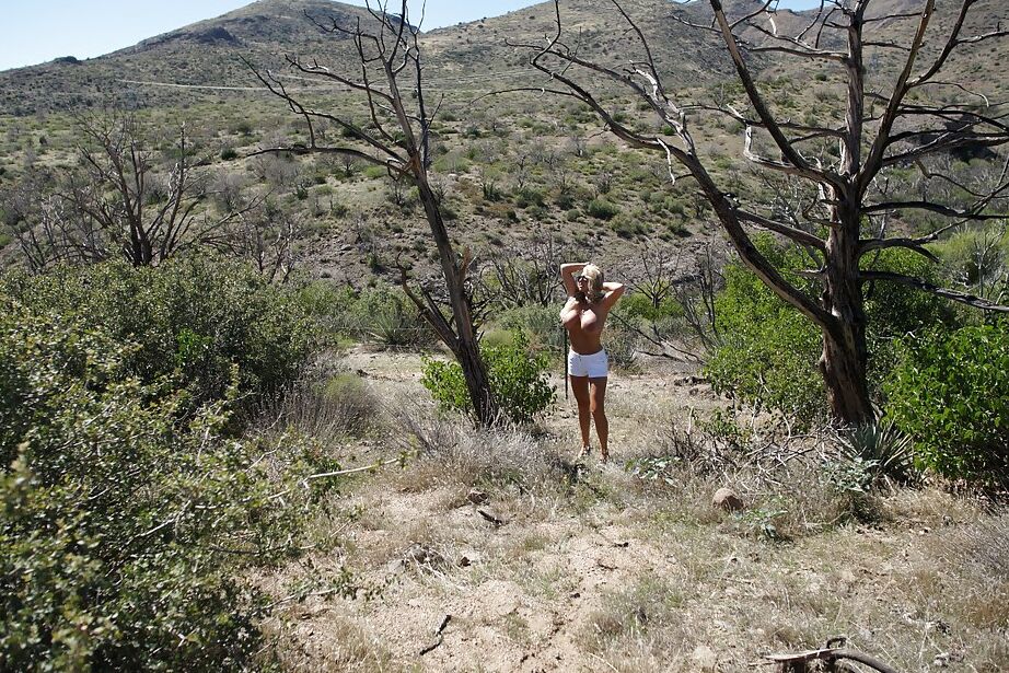 16P Ama de casa rubia juguetona con gafas de sol mostrando sus curvas calientes al aire libre