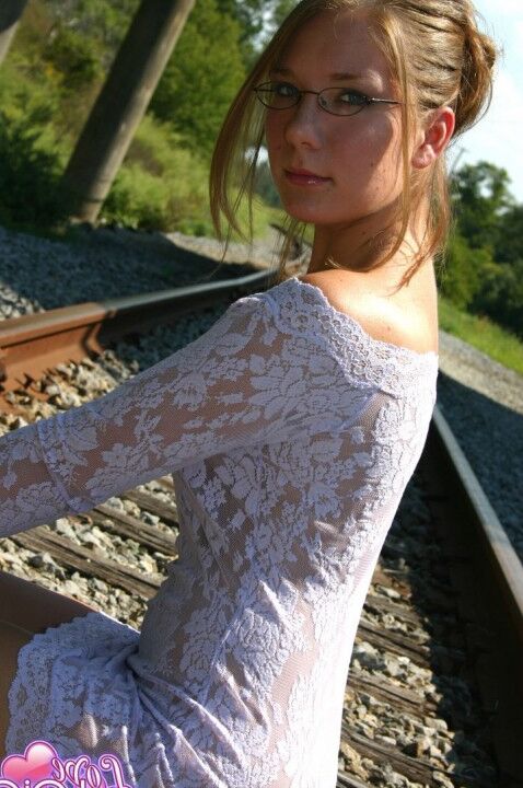 12P Amadora solo menina poss não nua em trilhos de trem com vestido apertado e óculos