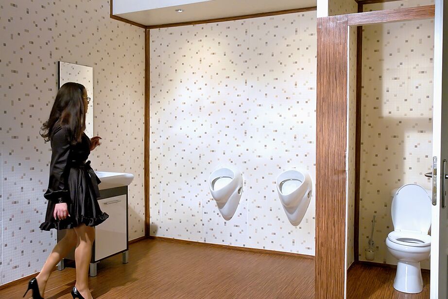 15P Mujer vestida con gafas se folla una polla asomando a través de un agujero glorioso en la pared del baño