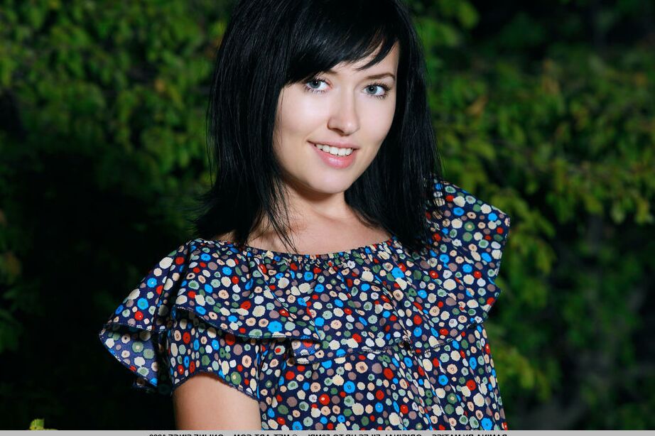 18P Dark haired teen Ramina gets bare naked in a yard next to fir trees