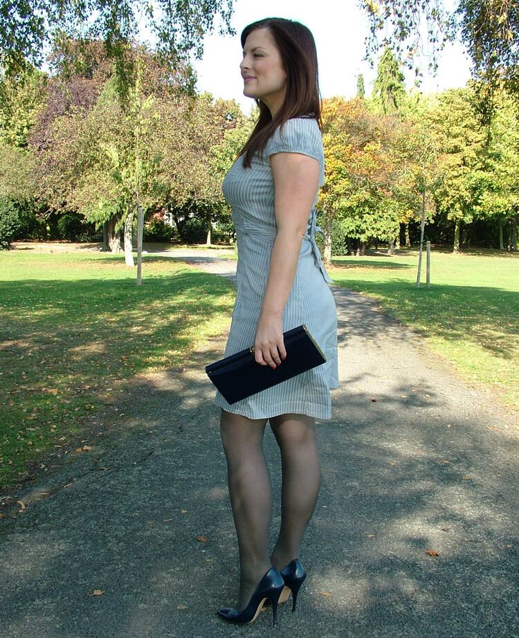 16P Mulher vestida mostra suas pernas e sapatos de náilon no parque