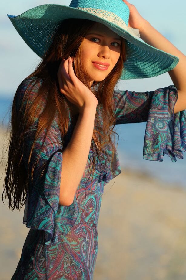 18P A bela adolescente Nicole K modelando nua na praia usando um chapéu de sol