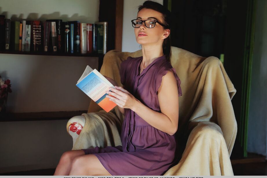 18P Thin teen takes off her glasses before modeling naked after reading in a chair