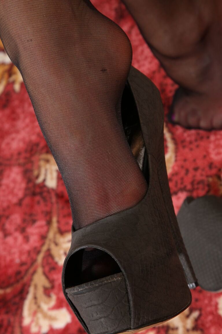 21P Sultry Jojo poses in nylon stockings and dangles high heel shoe