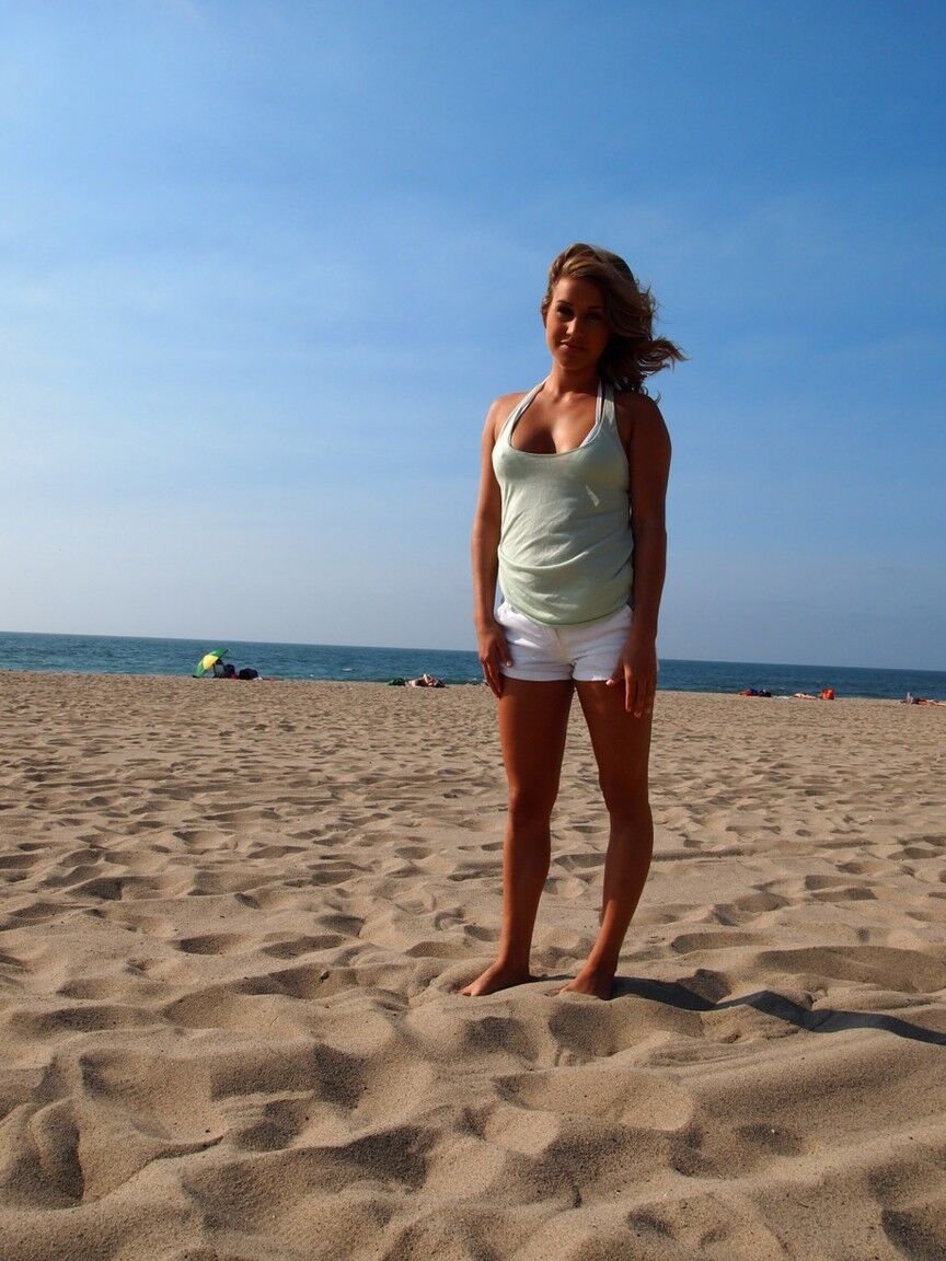 15P Blonde teenager strips off outerwear to model in a bikini on the beach