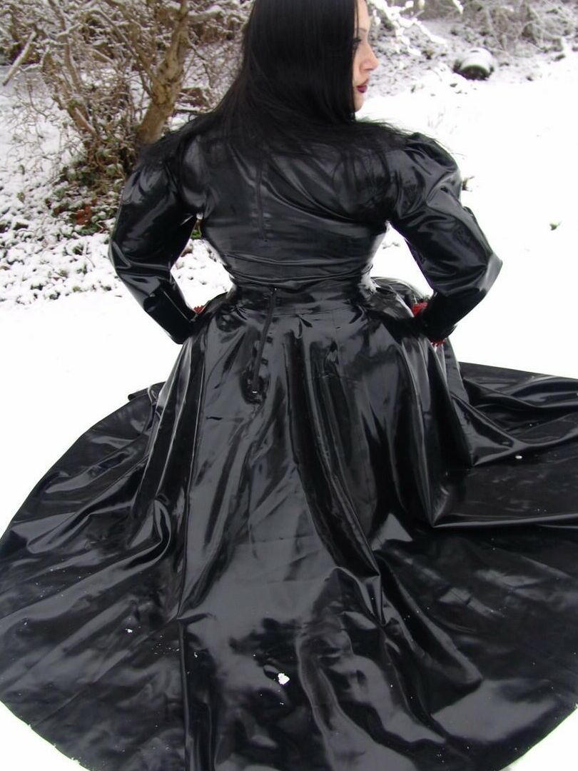 16P La mujer gótica Lady Angelina modela un vestido de látex negro sobre un suelo cubierto de nieve