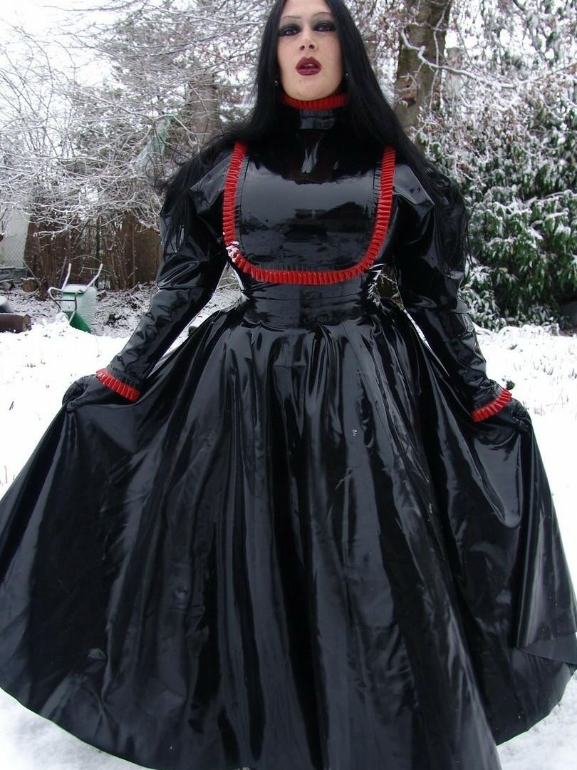 16P La mujer gótica Lady Angelina modela un vestido de látex negro sobre un suelo cubierto de nieve