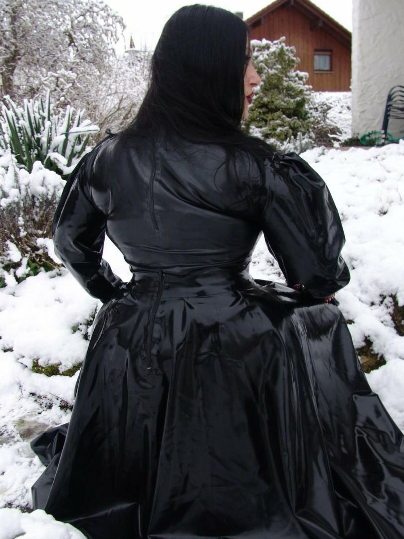 16P La mujer gótica Lady Angelina modela un vestido de látex negro sobre un suelo cubierto de nieve