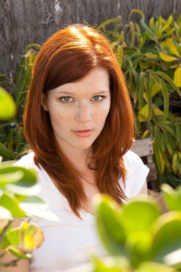 18P Natural redhead Mia Sollis casually strips naked on a patio bench