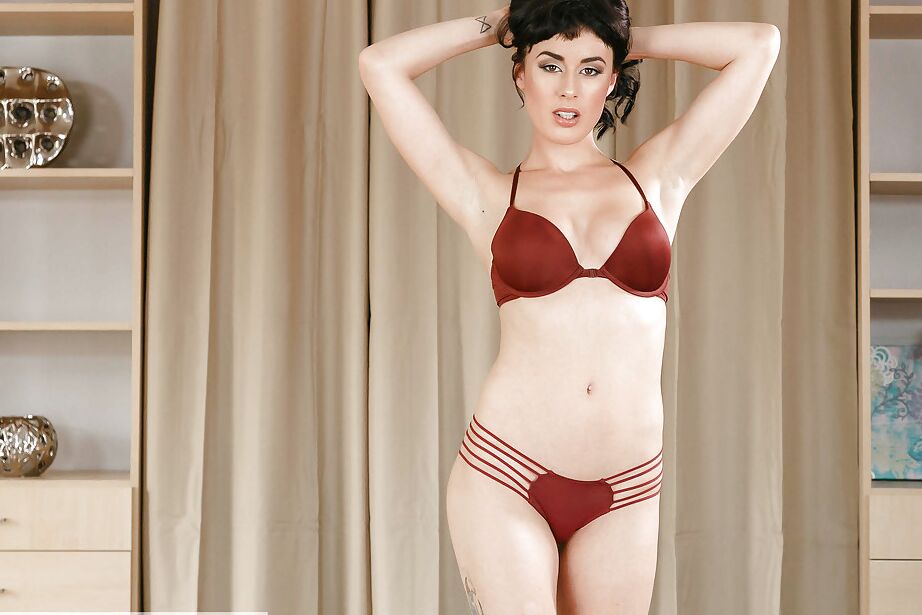 16P Brunette solo model Olive showing off long legs while removing clothing
