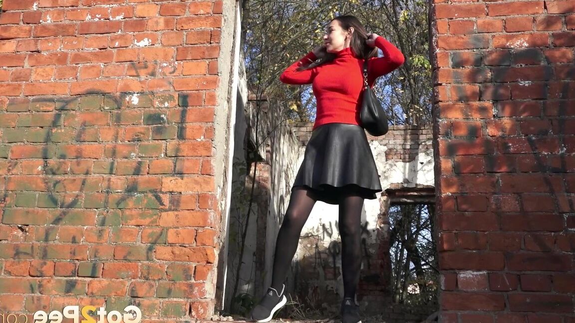 15P Pretty girl Sasha squats for a pee by a brick building in pantyhose