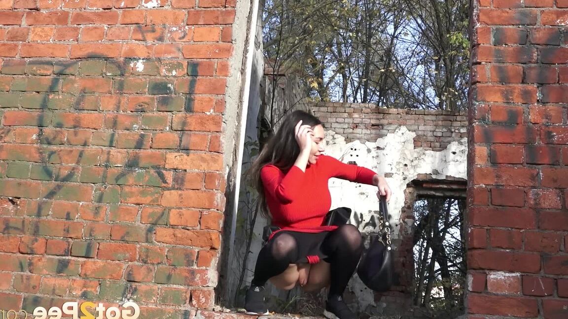 15P Pretty girl Sasha squats for a pee by a brick building in pantyhose
