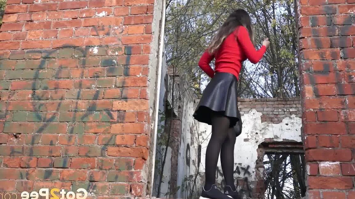 15P Pretty girl Sasha squats for a pee by a brick building in pantyhose