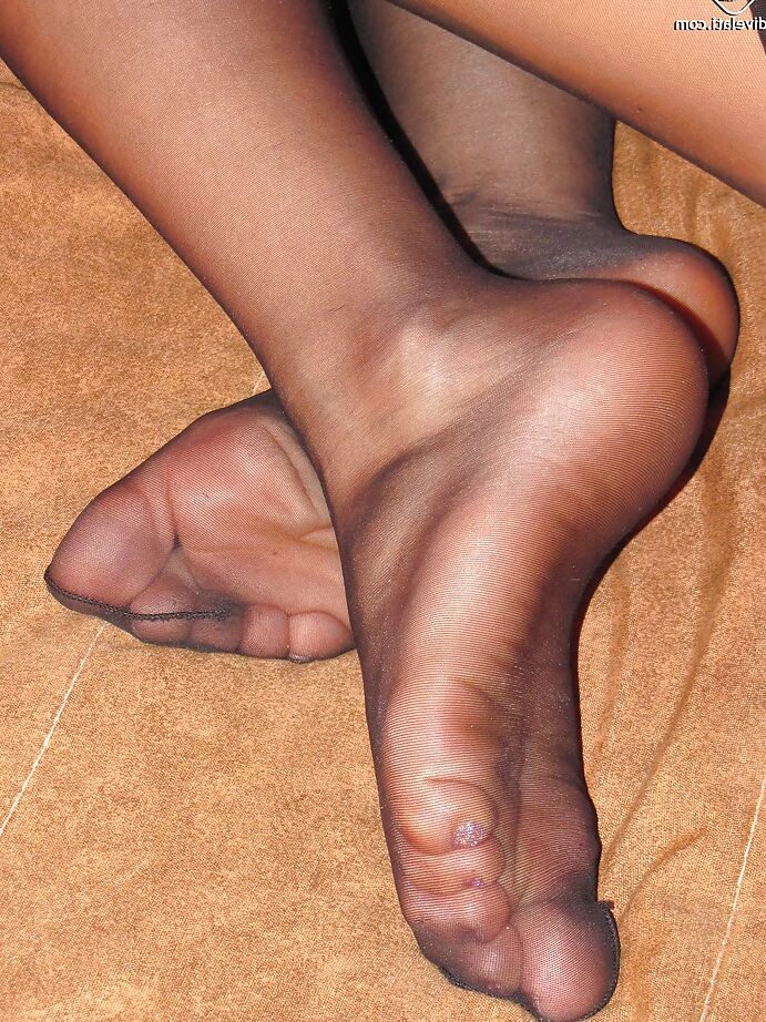 16P A deslumbrante menina morena Lucy está mostrando seus sapatos e pés vermelhos