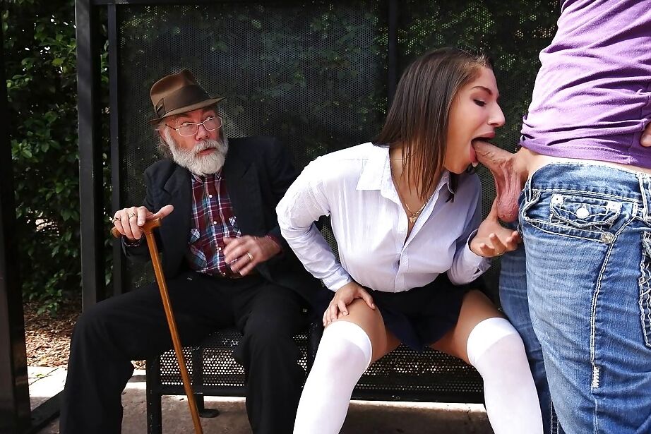 16P A estrela pornográfica adolescente Abella Danger, com meias longas, soprando um pau grande em público