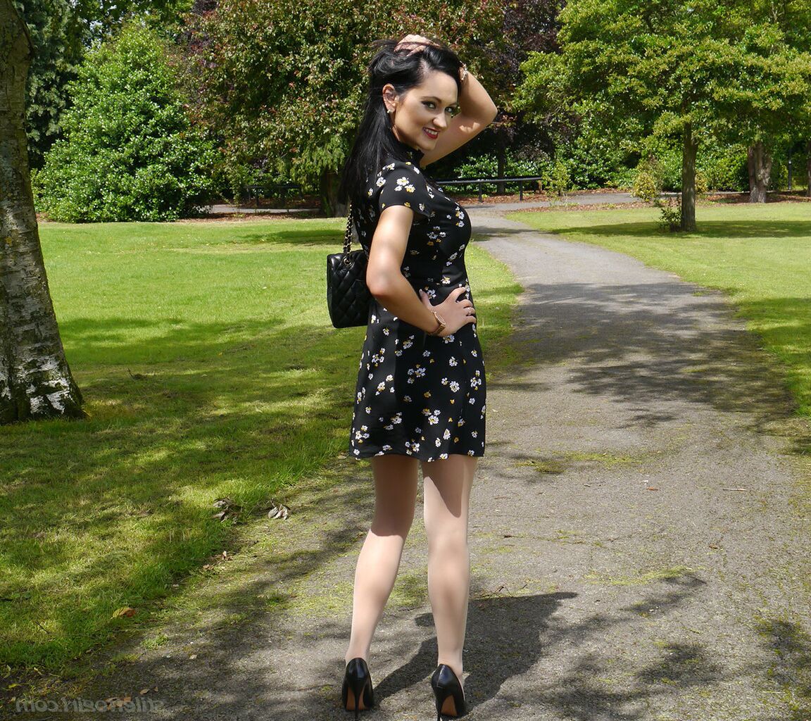 16P Clothed woman Maria dangles stiletto heels from hose covered feet in a park