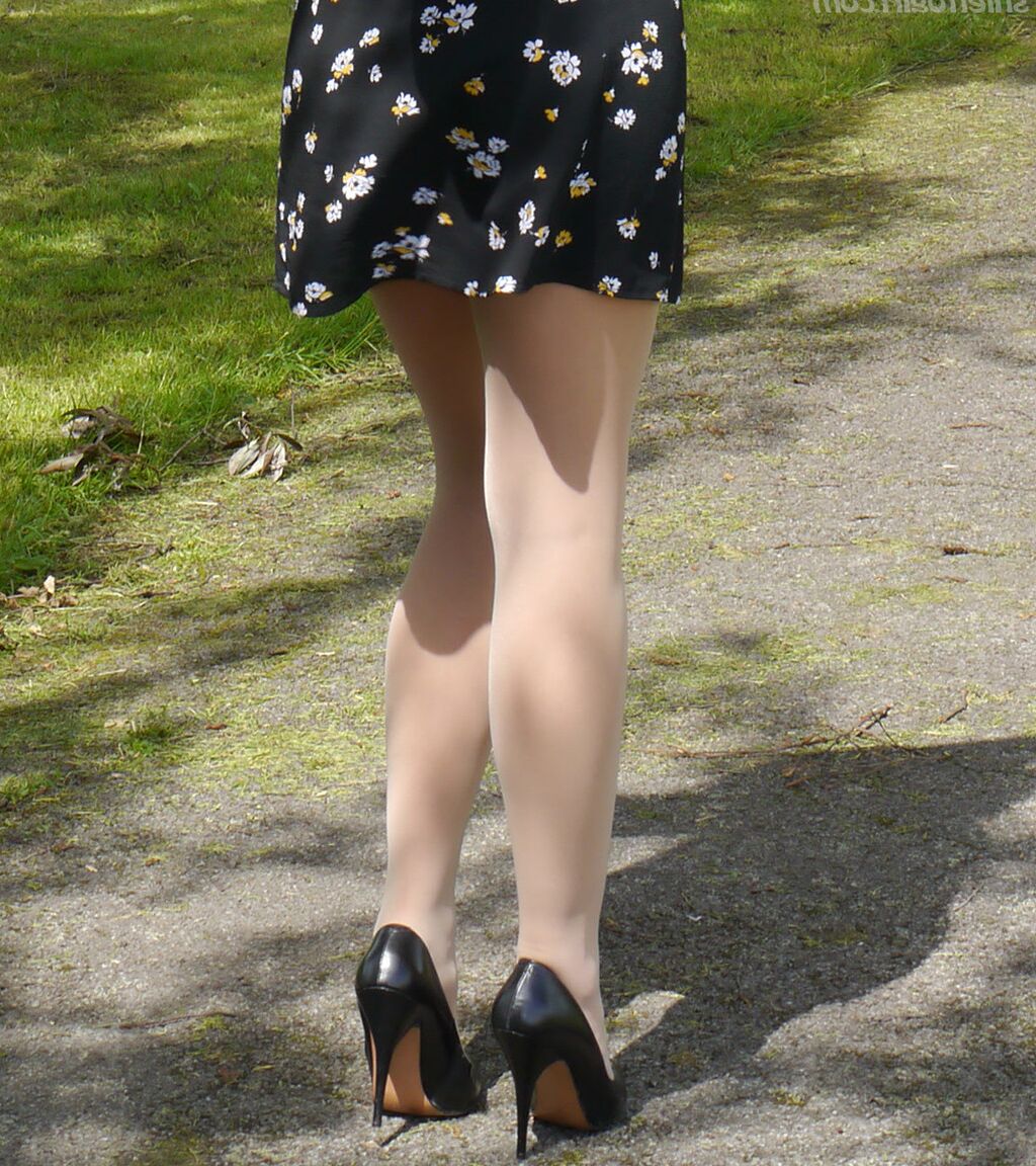 16P Clothed woman Maria dangles stiletto heels from hose covered feet in a park