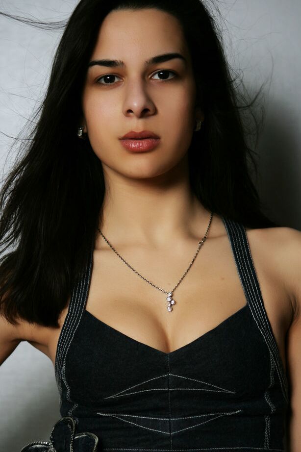 16P La joven morena Beth C se desnuda contra una pared después de quitarse la ropa
