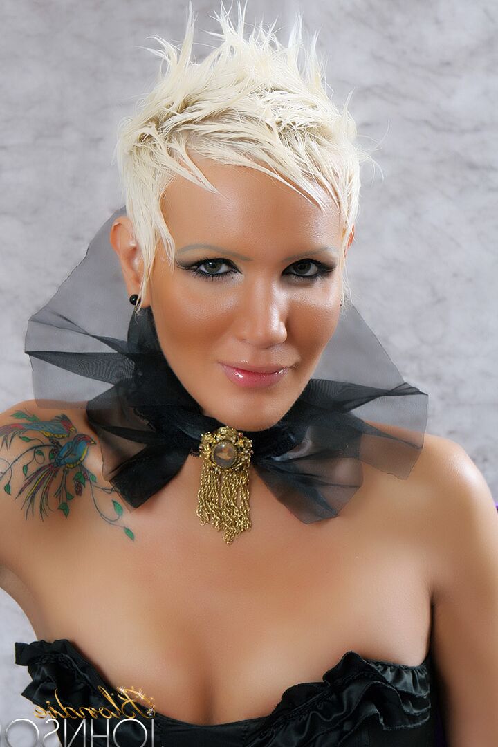 12P Eine sexy blonde Transe mit einem langen, kurvigen Schwanz in schwarzen Dessous
