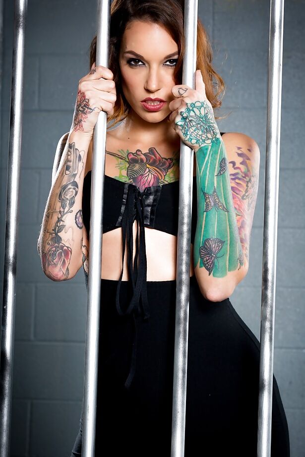 16P Presa con tatuajes posa con vestido negro y medias
