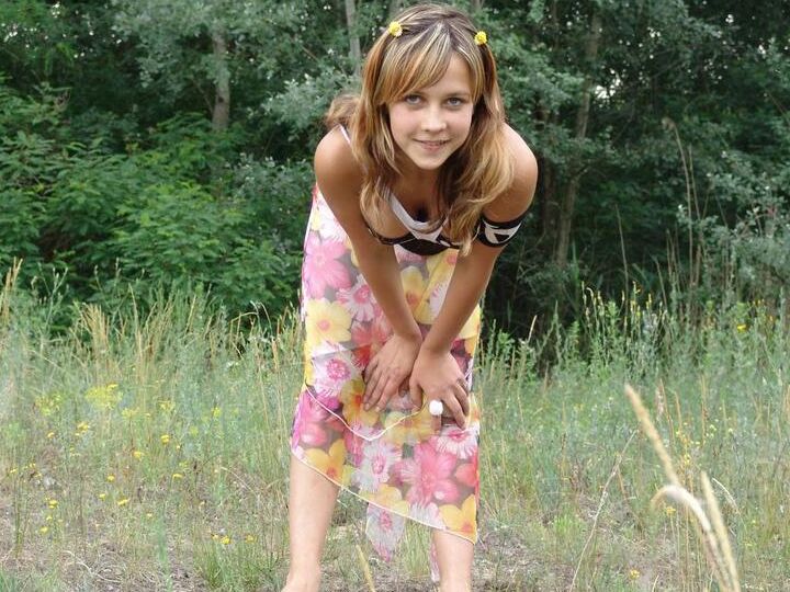 20P Barely legal cutie Liza strips naked in a clearing in front of a forest