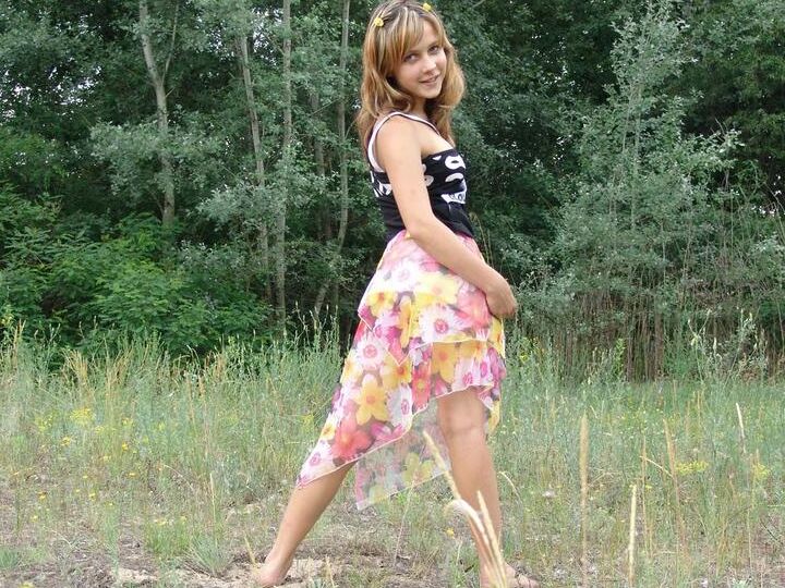 20P Barely legal cutie Liza strips naked in a clearing in front of a forest