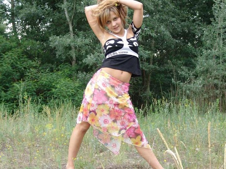 20P Barely legal cutie Liza strips naked in a clearing in front of a forest