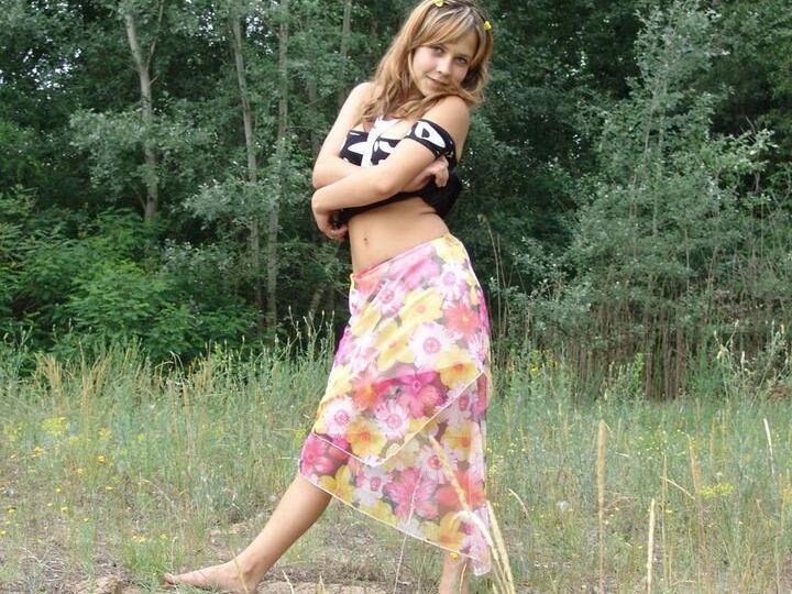 20P Barely legal cutie Liza strips naked in a clearing in front of a forest