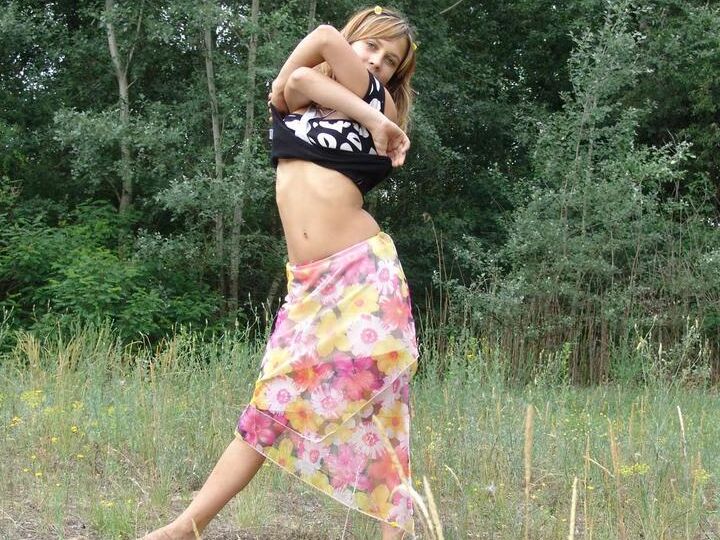 20P Barely legal cutie Liza strips naked in a clearing in front of a forest