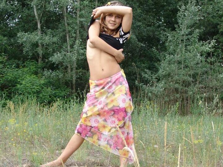 20P Barely legal cutie Liza strips naked in a clearing in front of a forest