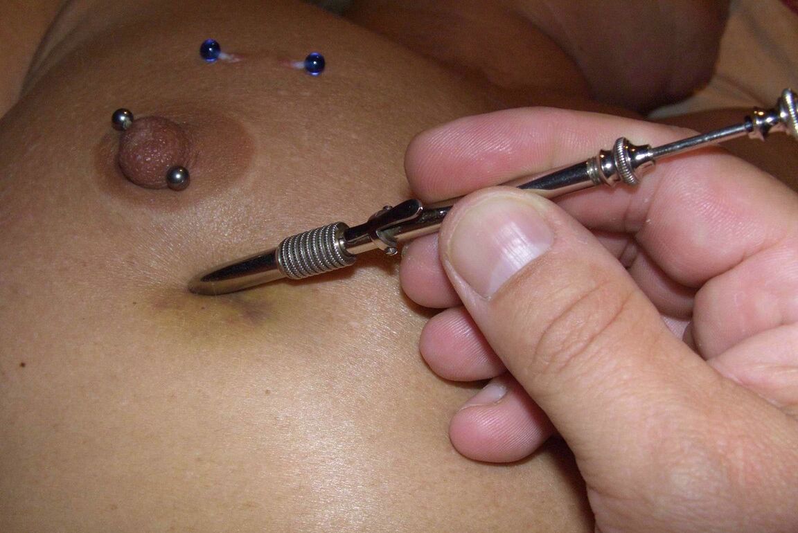 12P Close up action of a female having her breasts tortured with needles