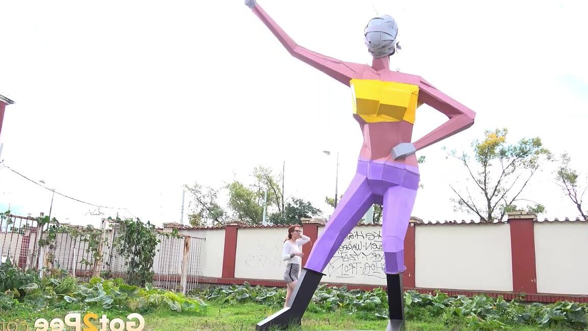 15P Gorgeous redhead squats and pees near a sculpture