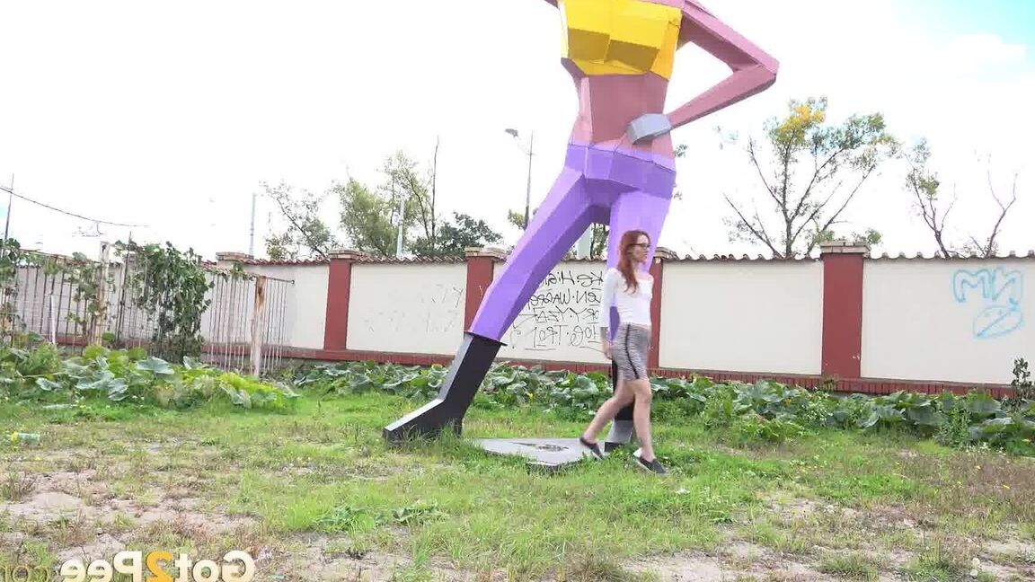 15P Gorgeous redhead squats and pees near a sculpture