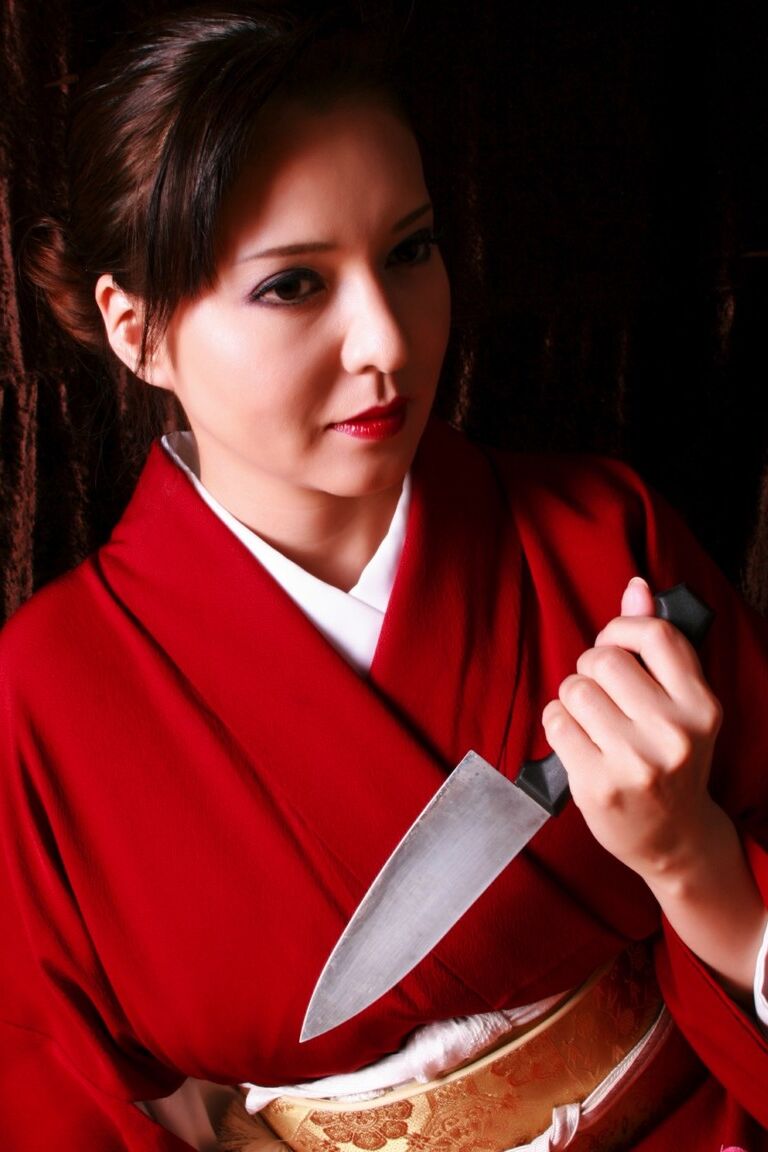 12P Une Japonaise arbore des lèvres rouges tout en produisant un couteau en costume traditionnel