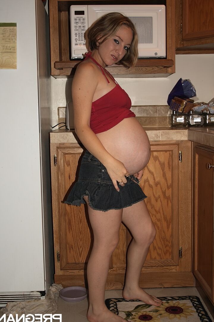 16P Kristi, une amatrice enceinte, montre ses fesses avant de jouer avec sa chatte dans la cuisine.