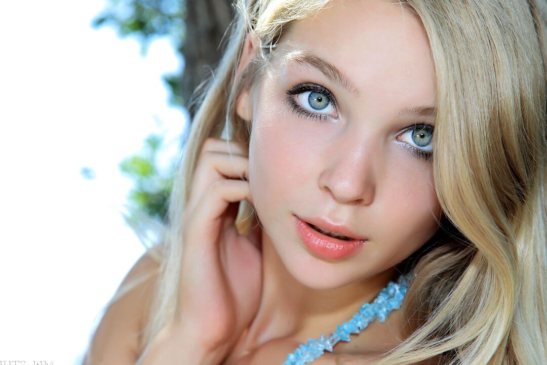 12P Beautiful girl with a pretty face displays her tan lined body in a tree