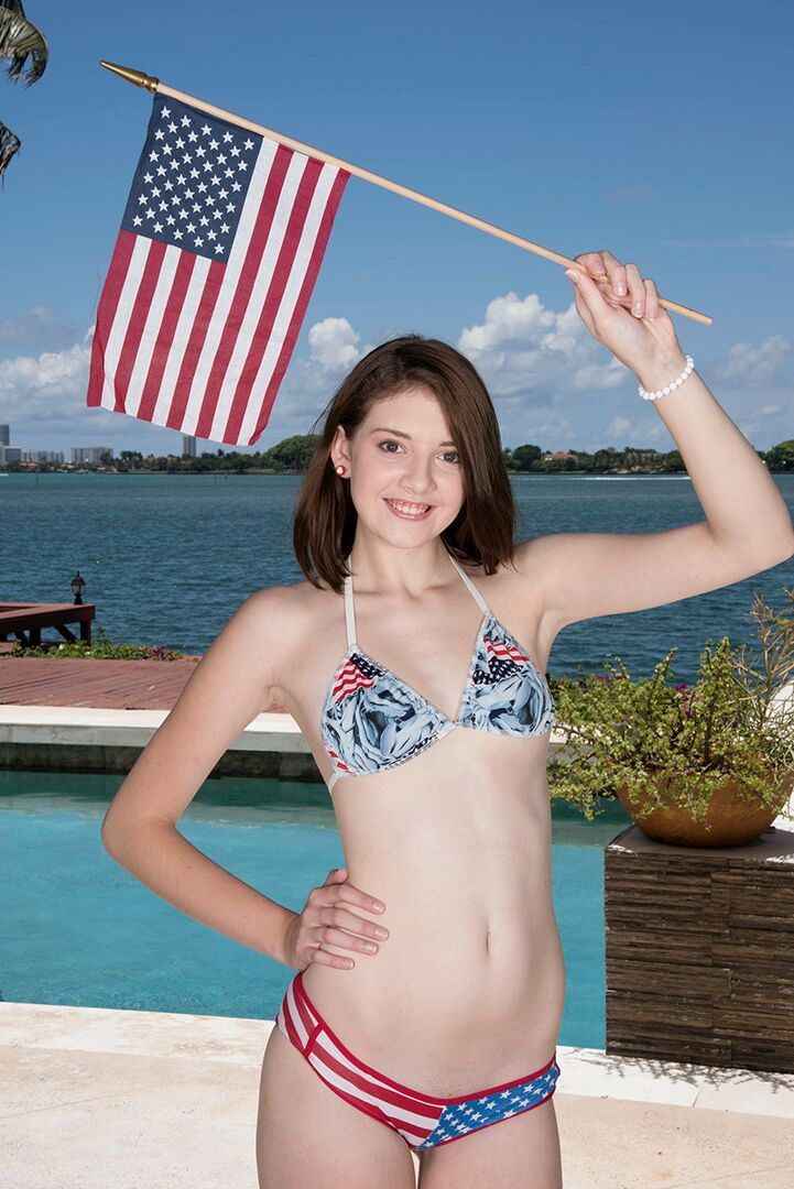 16P Sweet girl Blaire Ivory models a bikini while waving a USA flag