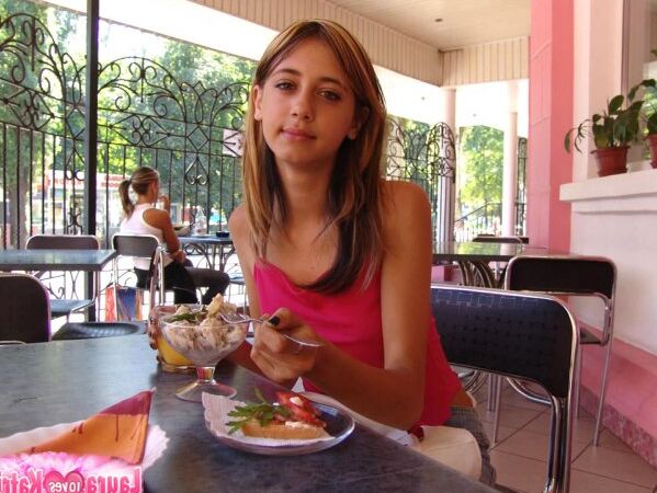 15P Ado aux gros seins en hauts ajustés roses prenant une collation