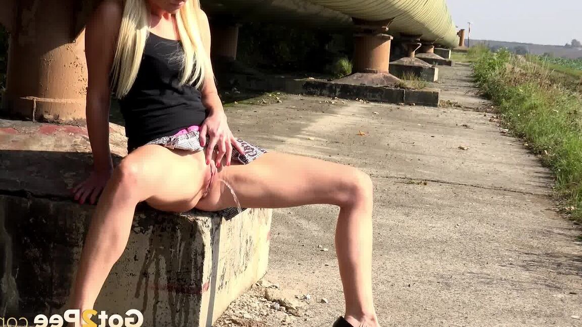 15P Blonde girl Nykla takes a pee near a pipeline that runs thru a farmer's field