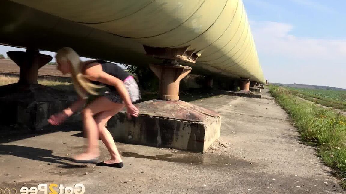 15P Blonde girl Nykla takes a pee near a pipeline that runs thru a farmer's field