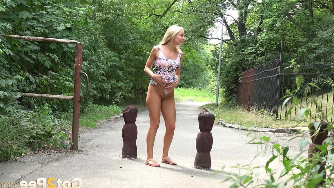 15P ブロンドの女の子ヴィクトリア・ピュアが公園の歩道で小便をするためにしゃがむ