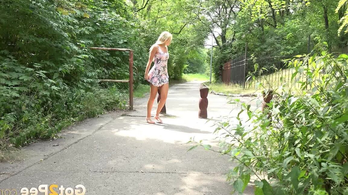 15P ブロンドの女の子ヴィクトリア・ピュアが公園の歩道で小便をするためにしゃがむ