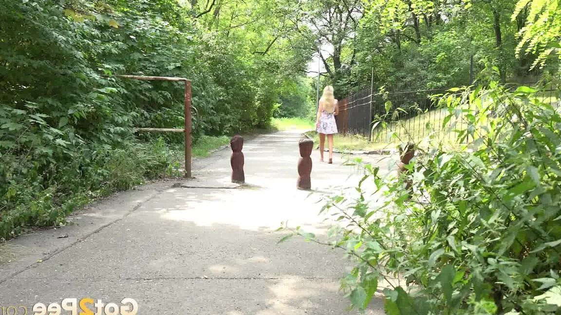 15P ブロンドの女の子ヴィクトリア・ピュアが公園の歩道で小便をするためにしゃがむ