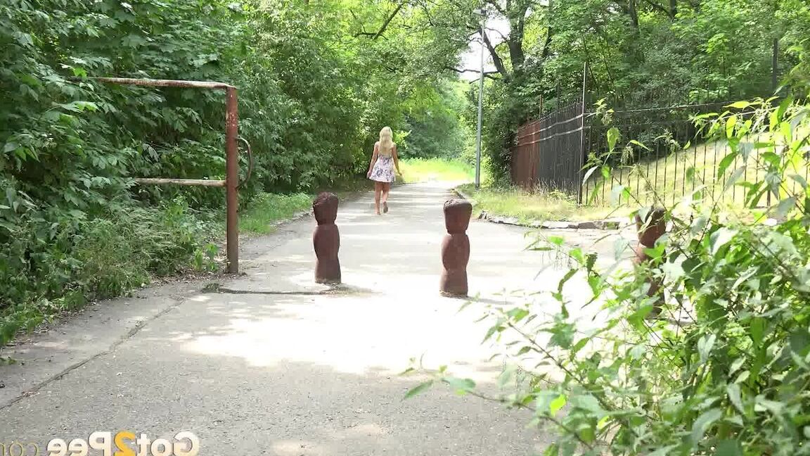 15P ブロンドの女の子ヴィクトリア・ピュアが公園の歩道で小便をするためにしゃがむ