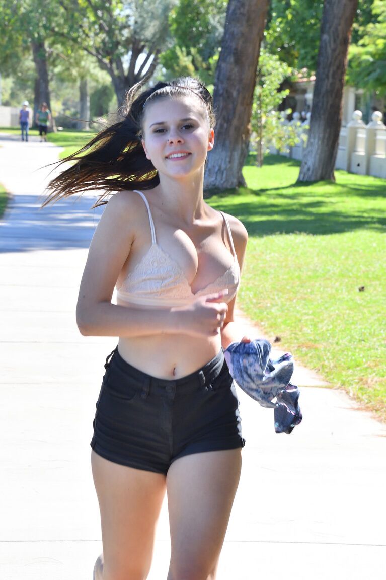 21P Sexy black haired girl Desiree rubs her twat and runs in a bra in the park